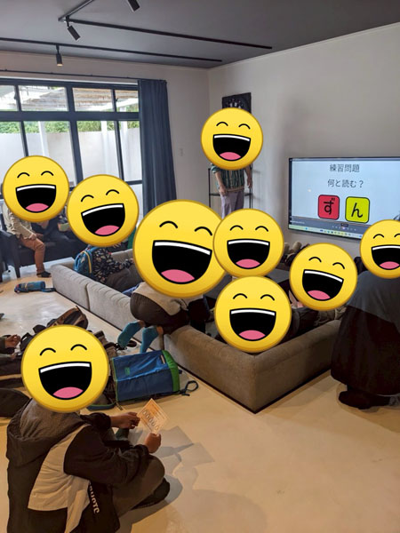 放課後等デイサービスの謎解きイベントの様子。児童達が室内でイベントの説明を受けています。