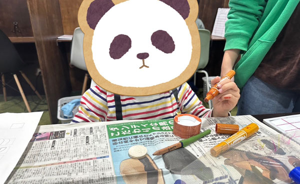 放課後等デイサービスの児童が3Dプリンターで作った制作物に色を塗っています