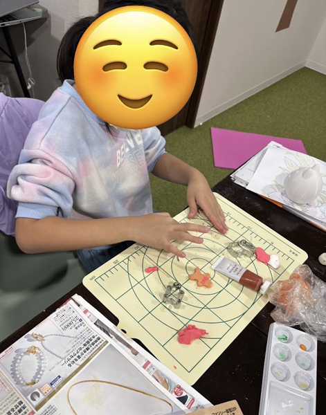 放課後等デイサービスの児童が紙粘土でクリスマスの小物を作る様子