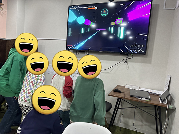 放課後等デイサービスでの運動を促す取り組みの様子。モニターに映し出された映像に合わせて子供たちが動いています。