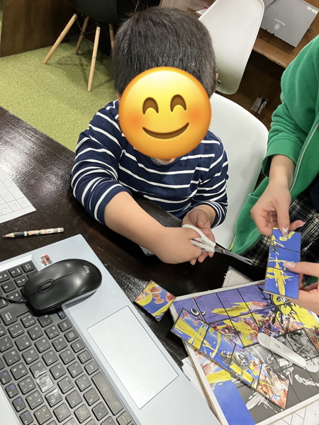 放課後等デイサービスの児童が好きな画像で作ったパズルを切り分けています